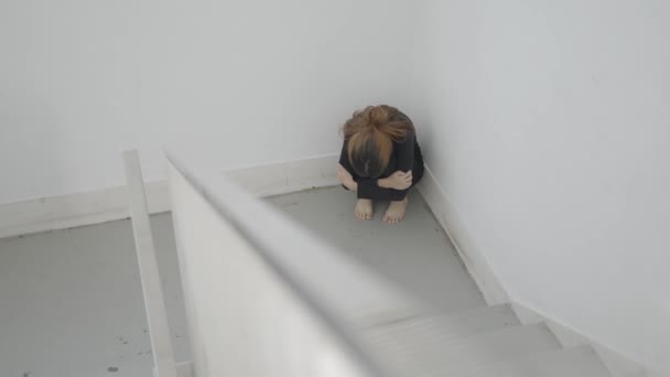 Young Scared Woman Sits Curled Corner Stairwell — Stockvideo