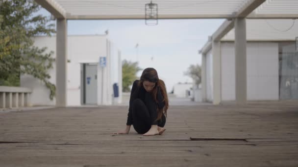 Mujer Joven Vestida Negro Sienta Puente Madera Mira Hacia Abajo — Vídeos de Stock