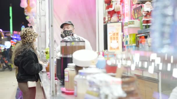 Frau Mit Chirurgischer Gesichtsmaske Kauft Nachts Waffeln Auf Einem Straßenmarkt — Stockvideo