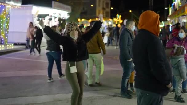 Cheerful Girl Pulled Face Mask Dancing Valencia Funfair Surrounded People — Vídeo de stock