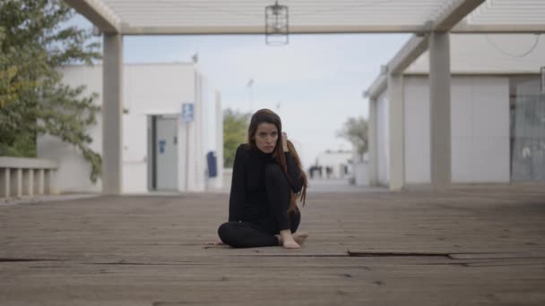 中央スローモの女の子服を着て黒座って上の木製の橋 — ストック動画