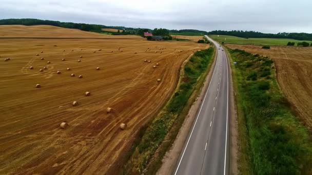 Vehicles Driving Long Asphalt Highway Farmland Rolls Hay Bales Aerial — ストック動画