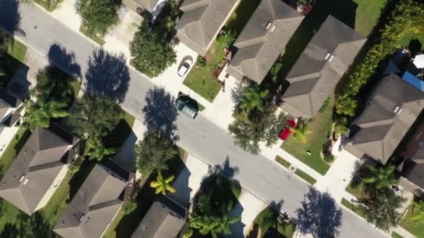 Top down drone shot of detached houses. Street with similar family houses on both sides. American estate