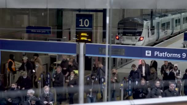 キングスクロス駅から列車で到着した後にチケットバリアを終了する乗客 高角度 ロックオフ — ストック動画