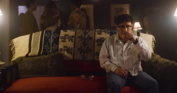 Man Sits Uncomfortably Party Sweats Smokes Drinks — Stock Video