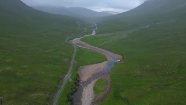 Pan Shot Reveals Car Passing Winding Road — Stockvideo