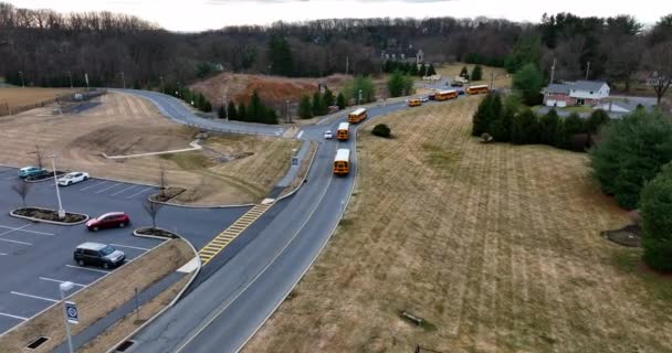 黄色のスクールバスの艦隊は 米国の地区の敷地を残します アメリカの学生のための交通機関 — ストック動画
