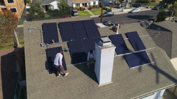 屋根の周りの空中の景色技術者の労働者が太陽電池パネルのメンテナンスをインストールして実行する ドローンショット — ストック動画