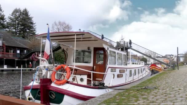 ナントのエルドレ川にドックされた狭い船の固定されたショットで 背中にフランスの旗が付いています — ストック動画
