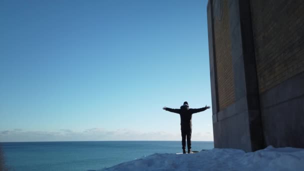 Wide Shot Man Raising Hands Salutation Hillside Overlooking Lake Ontario — Stockvideo