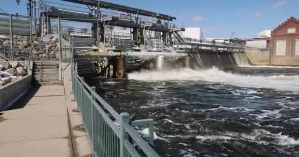 ゆっくりと流れる水でダムの方へ歩道を歩く — ストック動画