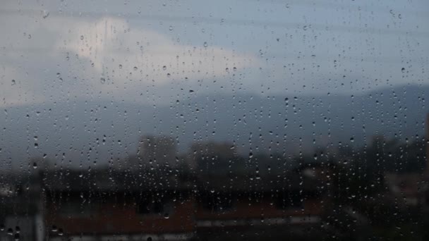 Dešťové Kapky Neustále Padají Okenním Sklem Městem Pozadí — Stock video