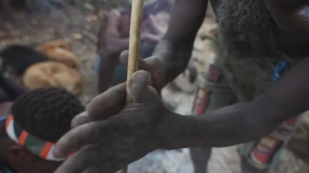 Cinematic shot of tribal african man doing fire with a wood stick. Traditional bushmen tribe, Tanzania, Africa 4K.
