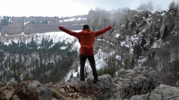 Man Stand Cliff Edge Overlook Winter Landscape Raising Arms Success — стоковое видео