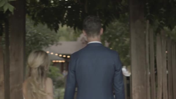 Blonde Young Bride Tall Groom Holding Hands While Walking Outdoors — Stockvideo