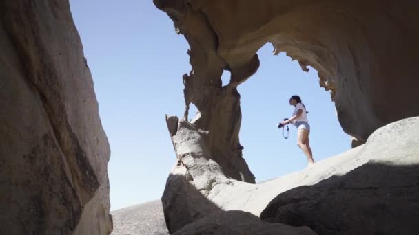 Young Woman Photographer Standing Rocky Arch Formation Mountains Desert Fuerteventura — Video