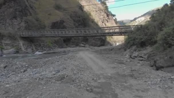 Metallic Bridge Spanning Rocky River Bed Mountainous Valley Surrounded Mountains — Stockvideo