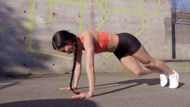 Woman doing core workout of plank with knee to elbow then pushup routine
