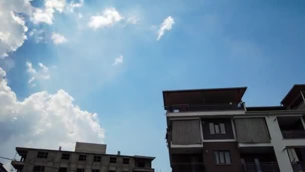 昼間の住宅の上空を青空に動き回る暗い雨や嵐の雲の経過時に撮影された低角度 — ストック動画