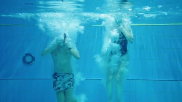 スローモーションカップル二人の若い十代の若者たちダイビングマスクと水着でプールに飛び込みます 水中静的ショットの友人は競争の中で一緒に泳ぐ — ストック動画