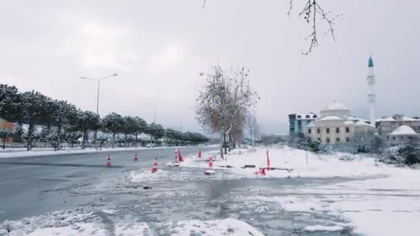 在多云的一天 汽车在土耳其一个清真寺前面的路上经过 冬季覆盖该地区的雪 — 图库视频影像