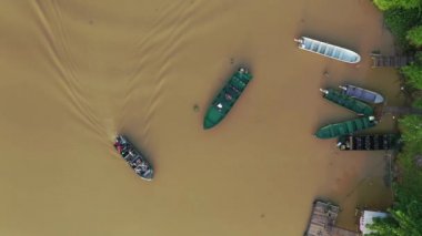 Drone view of fisherman cleaning his boat and another boat of tourist passing by