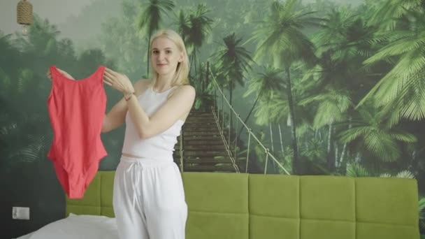 Młoda Atrakcyjna Blondynka Biały Kobieta Pokazując Jej Nowy Czerwony Jednoczęściowy — Wideo stockowe