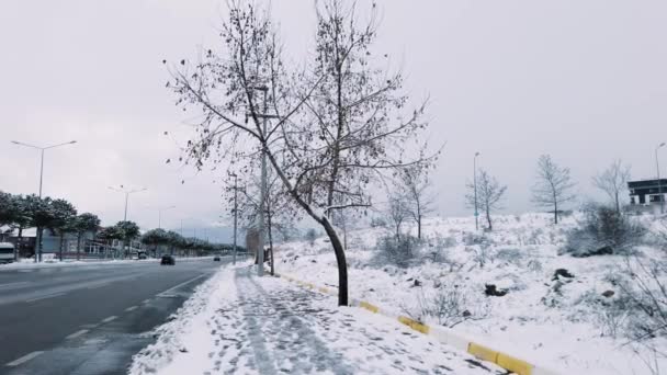 在一个多云的日子里 在土耳其的杰尼兹里 有一辆汽车经过街道 在一个多云的日子里 街道旁边被积雪覆盖的景象 — 图库视频影像