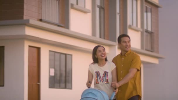 Happy Young Couple Walking Street Sunset Pushing Baby Stroller — стокове відео