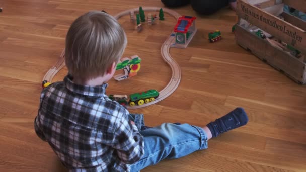 Criança Sentada Chão Enquanto Assistia Trem Brinquedo — Vídeo de Stock
