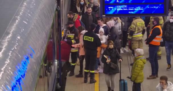 2022年ロシアのウクライナ侵攻 難民危機の間にワルシャワの中央鉄道駅 消防士が列車に入るのを助ける — ストック動画