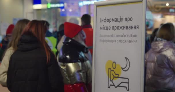 2022年ロシアのウクライナ侵攻 難民危機の間にワルシャワの中央鉄道駅 宿泊情報にオンラインで立って難民 — ストック動画