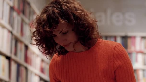 Focused Caucasian Curly Woman Studying Book Shelves Library — Stock Video