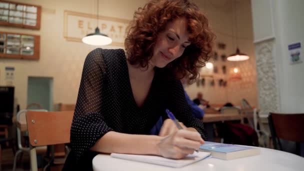 Eğitimli Genç Kadın Kafe Masasında Oturan Kağıda Notlar Yazıyor — Stok video