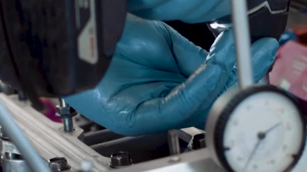 Sebuah Mesin Mekanik Pengetatan Baut Dengan Sarung Tangan Lateks Biru — Stok Video