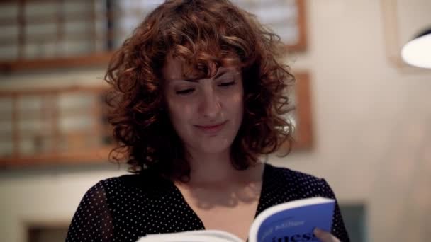 Pretty Curly Brunette Woman Reading Novel Book Pages Smiling — Stockvideo