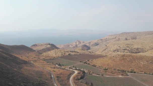 在阳光灿烂的日子里 以色列戈兰高地被丘陵地带和农业农场环绕的加利利海令人叹为观止的景观空中转景镜头 — 图库视频影像