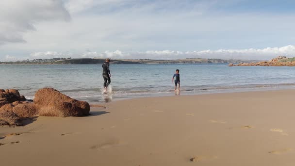 ชายและล กชายของเขาว ายน าในช ดเป ยกบนชายหาดชายฝ ยบสงบบนเกาะฟ — วีดีโอสต็อก