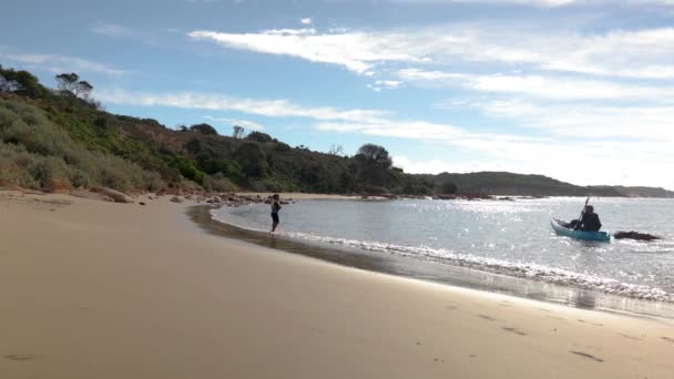 Seorang Pria Mengayuh Kayunya Sepanjang Pantai Sementara Anaknya Berjalan Sepanjang — Stok Video