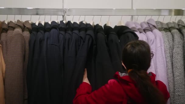 顾客看服装店陈列在衣架上的衣服 — 图库视频影像