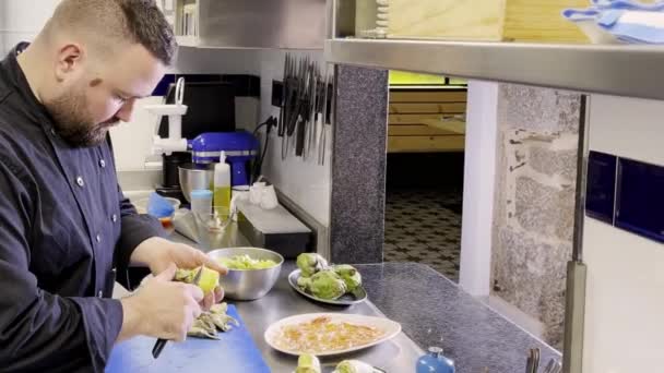 Caucasian Cook Pealing Cutting Aartichokes Restaurant — Stock Video
