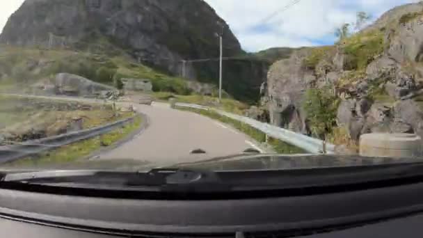 天気の良い日にはノルウェーのロフトテンで車を運転しながら丘陵地帯の風景 — ストック動画