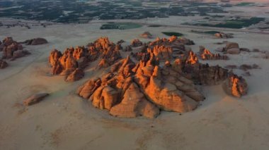 Manzaralı kırmızı kumtaşı tepelerinin insansız hava aracı görüntüsü, Al Ula 'da gün batımı, Suudi Arabistan