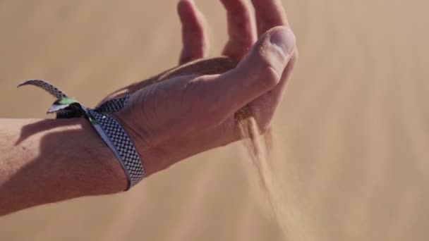 人間の手から落ちて風に乗って飛ぶサハラ砂漠の粒子の乾燥砂 — ストック動画