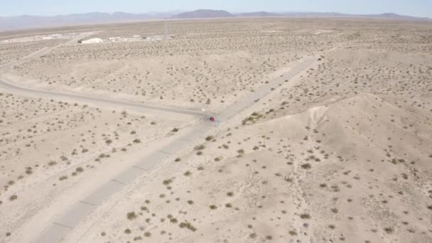 Vue Aérienne Suivant Une Voiture Rouge Traversant Désert — Video