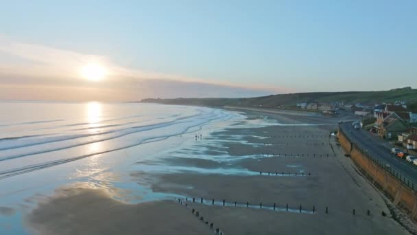 Sandsend, Whitby, North Yorkshire Coast aerial drone movement from sea towards sea and dog walkers. Early morning , March 2022. DJI Mavic 3 Prores Clip2