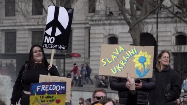 站在特拉法加广场一个喷泉旁边的妇女手持各种标语 上面写着 没有核战争 乌克兰人抗议俄罗斯入侵乌克兰 — 图库视频影像