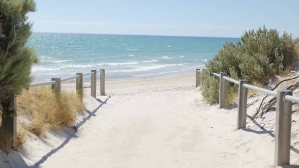 晴れた日に手すりのある砂浜の道を歩く — ストック動画