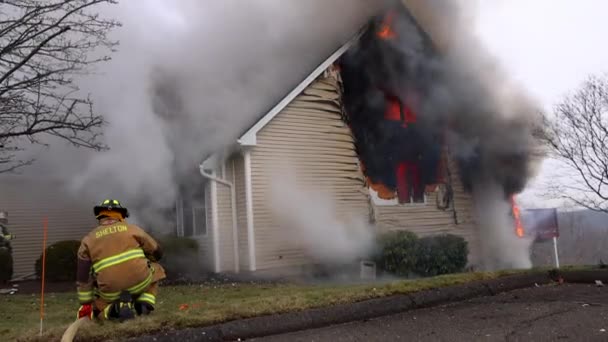 Firefighter Kneels Holding Fire Hose Burning Residential House — Vídeo de Stock