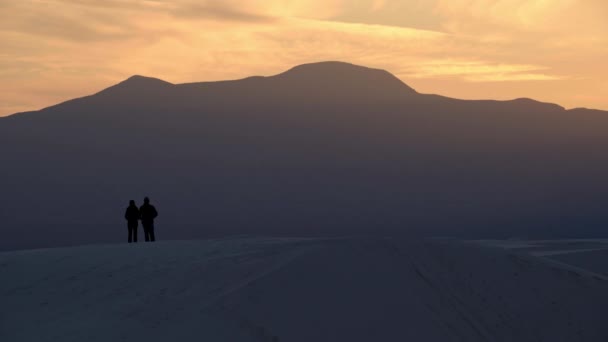 Couple Stand Silhouetted Hill Overlooking Sunset Large Mountains — Stock Video